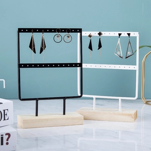 Dual-layer metal earring stand with wood base in black and white finish macro view
