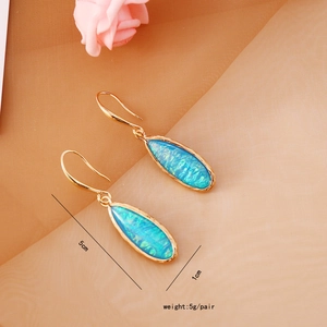 Detail of bohemian water drop earrings with blue opal and gold frame, size 5cm x 1cm