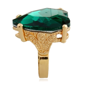 Side view of heart-shaped green gemstone ring with golden hollow filigree band detail