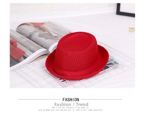 Detail of red mesh fedora hat featuring a matching satin ribbon on white metal grid