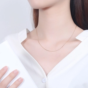 Minimalist 925 sterling silver golden snake bone necklace worn by a fashion model