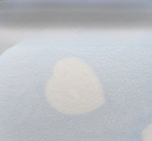 Detail of light blue four-way stretch fabric with heart patterns and soft texture