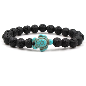 Detail of lava rock beaded bracelet with a turquoise turtle charm on a white background