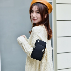 Sac bandoulière noir pour téléphone avec zip cœur sur une tenue de pull en maille
