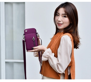 Détail du sac à téléphone en nylon violet avec fermeture éclair cœur et bandoulière