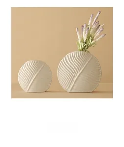 Detail of white ceramic flat leaf-pattern vases with textured engraving in macro view
