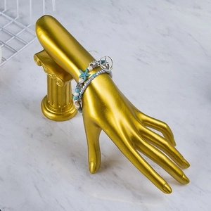 Multi-layer beaded starfish bracelet on golden hand mold display with marble background