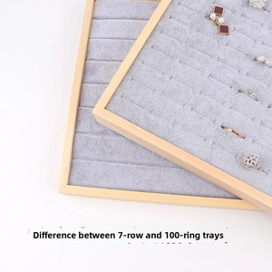 Detail of wooden jewelry tray with grey velvet lining and seven-row ring display slots