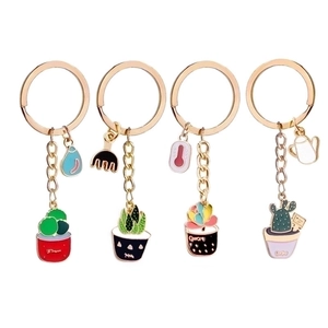Detail view of four gold-plated keychains featuring colorful enamel potted plant pendants