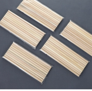 Detail view of natural wooden hexagonal pencils in clear plastic bags on a dark background