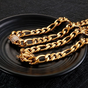 Golden flat Cuban chain necklace with sparkling diamond-set clasp on a black plate