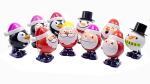 Detailed group shot of wind-up Christmas toys featuring Santa, snowman, and penguins