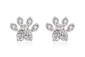 Detail of silver cat paw stud earrings featuring a heart-shaped cubic zirconia stone