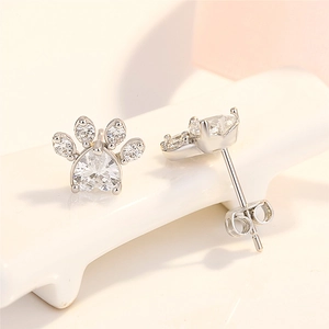 Close-up of paw earrings with clear heart-shaped zirconia in silver plating