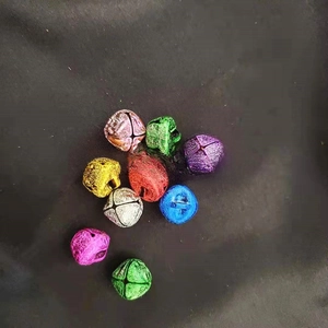 Close-up of assorted colorful metal cross-bell ornaments for DIY crafts and pet collars