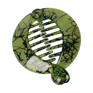 Detail of green tortoiseshell banana hair clip with resin marble texture and comb teeth