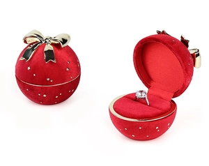 Red velvet spherical ring box with a gold bow in closed and open display views