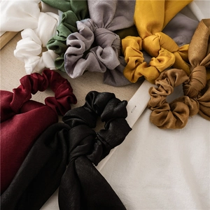 Detail of assorted silk satin scrunchies with long ribbons in multiple elegant colors