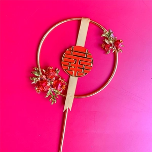 Detailed view of red berries and golden leaf accents on a wedding cake topper