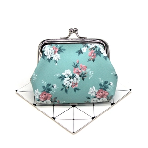 Detailed view of floral canvas coin purse with vintage metal clasp on a geometric card