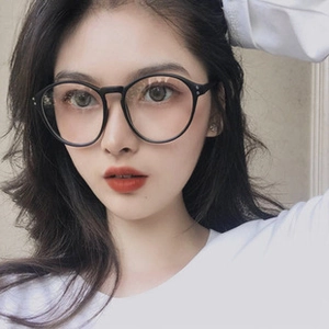 Close-up of black round full-rim glasses worn by a female model for a vintage facial look