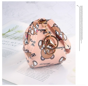 Close-up of pink coin purse with British bear print and gold metal keychain on a magazine