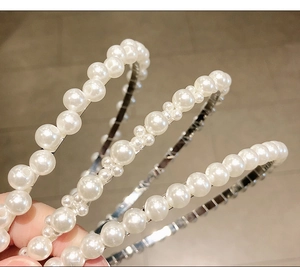 Close-up of handmade pearl headbands featuring elegant beads on a slim metal ring