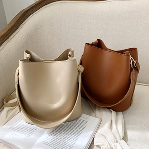 Minimalist wide-strap bucket bag for women in beige and tan leather for 2024 fashion