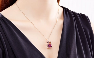 Close-up of a square gradient gemstone pendant necklace on a silver chain worn by a model