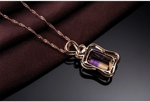 Detail of rose gold necklace with square bicolor gemstone pendant on water-wave chain