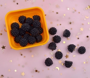 Macro view of realistic black mulberry resin charms for DIY crafts and phone case decor