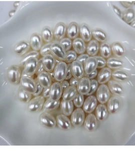 Macro shot of 7.5-8mm natural white freshwater rice pearls in a shell-shaped ceramic dish