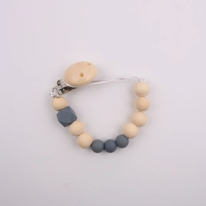 Detailed view of silicone and wooden pacifier clip with grey beads and geometric accents