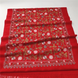 Detailed embroidery of red floral patterns and tassel fringe on a thick pashmina shawl