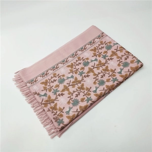 Detailed embroidery of floral patterns and tassels on pink cashmere-like winter scarf
