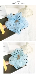 Detailed texture of blue organza scrunchie with black polka dots in retro French style