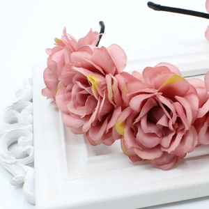 Detail of handmade pink fabric rose headband on vintage white frame decoration