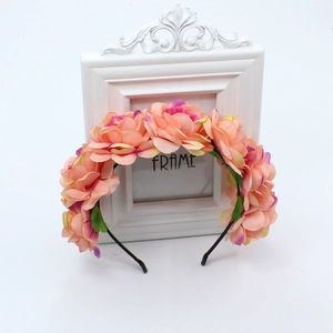 Detailed view of handmade silk rose headpiece on a vintage white decorative frame