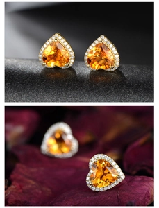 Detail of heart-shaped yellow crystal earrings with zircon halo on floral petals