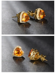 Close-up of heart-shaped orange citrine earrings with gold plating and pavé diamonds