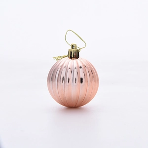 Detail of rose gold Christmas ball with vertical ribbed texture and gold hanging cap