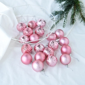 Pink electroplated Christmas balls with assorted textures in a metal basket