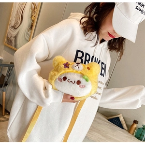 Détail d'un sac ours en peluche jaune et blanc avec broderie étoile sur un mannequin
