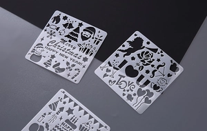 Detailed view of three square plastic stencils for DIY album scrapbooking and painting