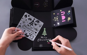 Close-up of DIY explosion box black cardstock with Christmas stencil painting and writing