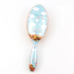 Detail view of transparent hairbrush featuring rainbow cloud pattern and floating sequins