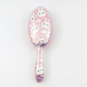 Detail of pink transparent hairbrush featuring cute rabbit print and holographic sequins