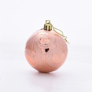 Detailed view of a rose gold Christmas ball with spiral texture and glitter accents