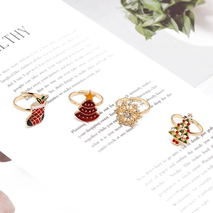 Detail of Christmas themed adjustable gold rings with enamel snowman and snowflake designs