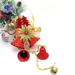 Close-up of red metal bells and gold Merry Christmas sign on a festive ornament